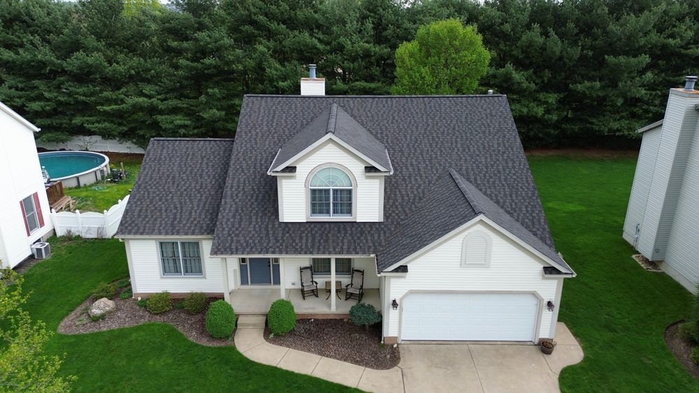 Drone view of a finished gray shingle roof with white trim on a two-story Northeast Ohio home by Firestone Roofing & Restoration.